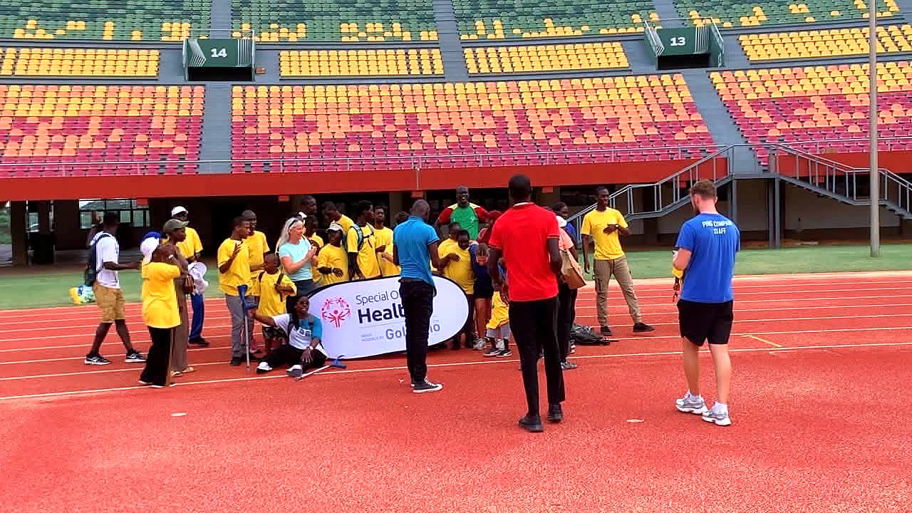 Participants et encadrants réunis sur la piste d'athlétisme autour d'une banderole Special Olympics